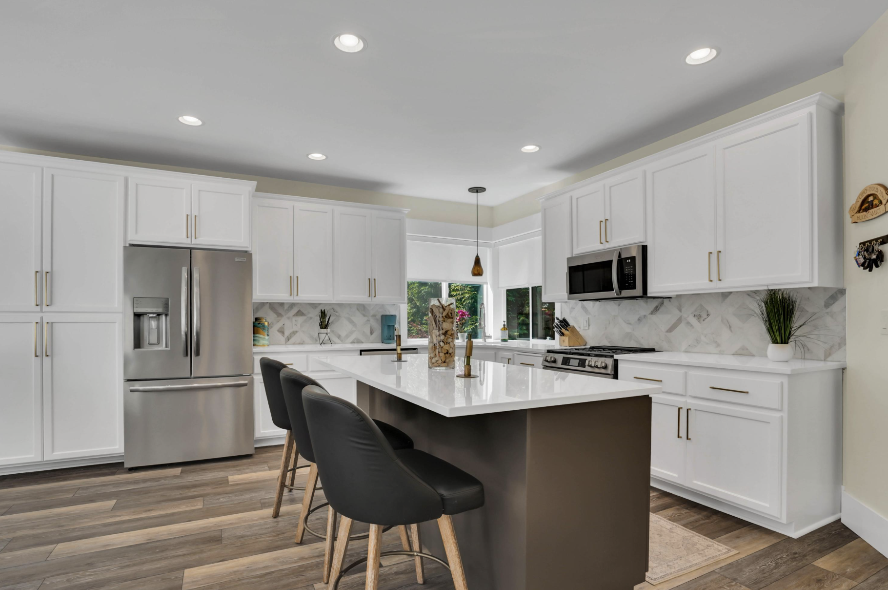 Bright real estate interior with warm wood floors and a kitchen view